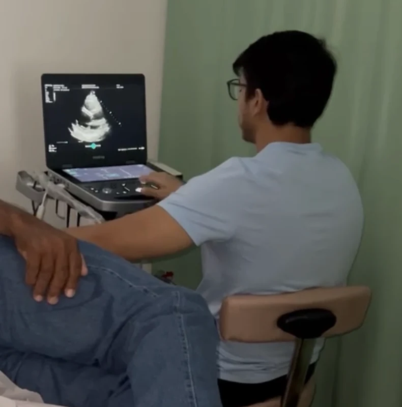 Profissional realizando ecocardiografia em ambiente clínico real.